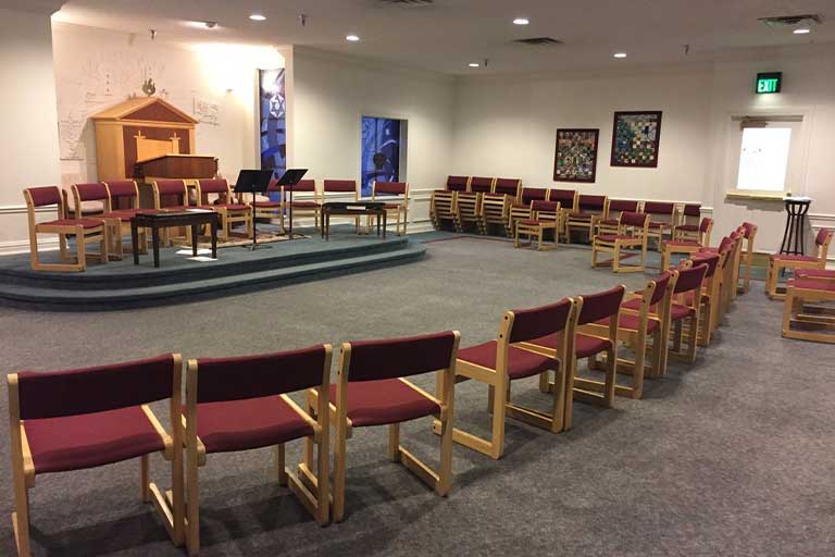 Empty chairs in semi-circle facing podium in chapel