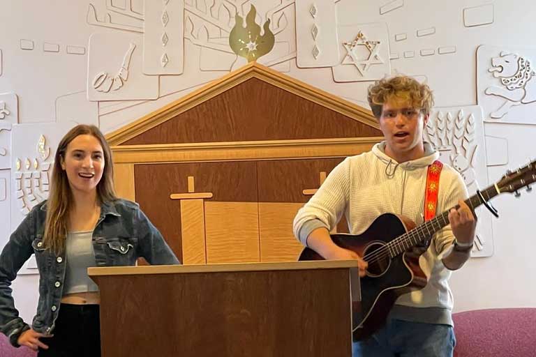 Male and female performers lead chapel in song.